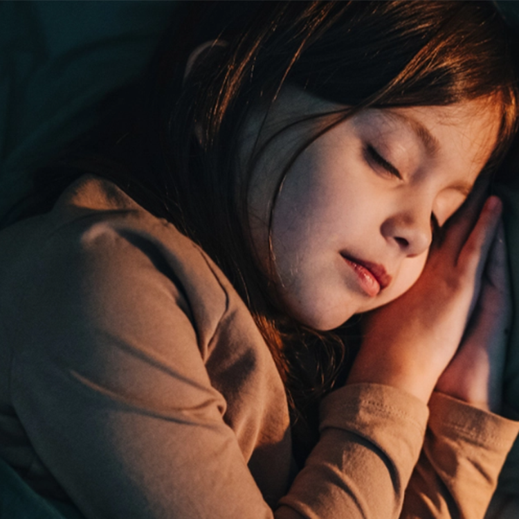 Barn som sover rolig i sengen – trygg og avslappet søvn.