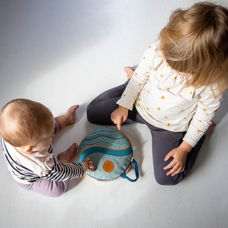 To barn som leker med en sansestimulerende pute på gulvet – lek, trygghet og utvikling.