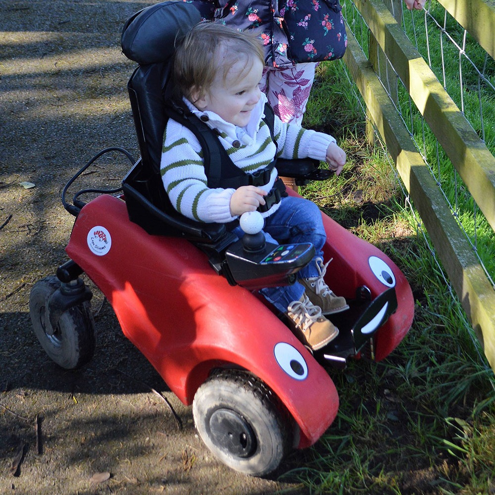 Barn som sitter i en Wizzybug.